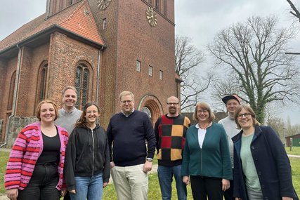 Eine Gruppe Frauen und Männer steht vor einer Kirche - Copyright: Annkathrin Bornholdt