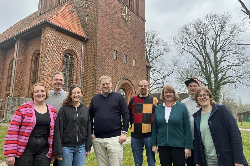 Eine Gruppe Frauen und Männer steht vor einer Kirche - Copyright: Annkathrin Bornholdt