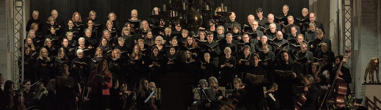 Viele Menschen singend im Dom zu Lübeck.