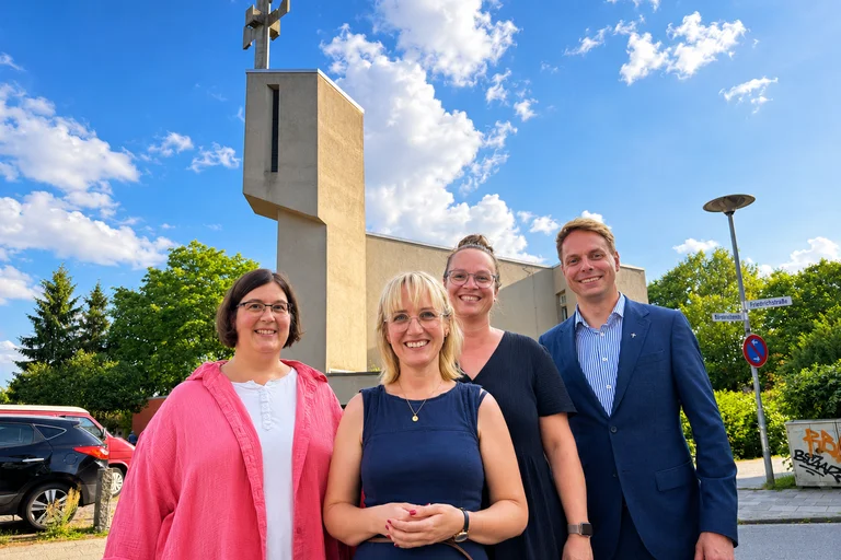 vier Personen vor einer kirche